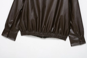 Detail of faux leather bomber jacket showing elastic hem and snap button cuffs