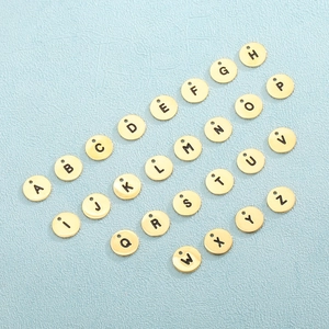Polished gold stainless steel round alphabet pendants with A-Z letters on blue background