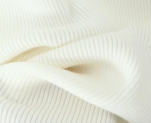 Gros plan sur un tissu en maille côtelée blanche montrant la texture et les détails