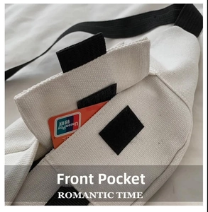 Detail view of white canvas chest bag featuring a front pocket with black velcro closure