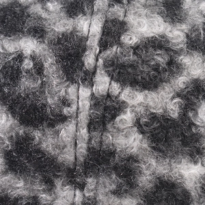 Macro shot of thick black and white lamb wool fabric with premium sewing detail