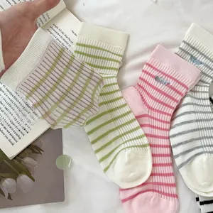 Detail of ribbed cotton blend socks with fine stripes and embroidery on a fabric background