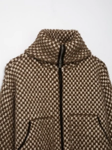 Gros plan détaillé sur le tissu en maille texturée de la veste bomber bicolore à motif