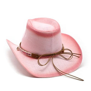 Detailansicht eines rosa Stroh-Cowboyhuts mit Ethno-Webband und dekorativen Muscheln