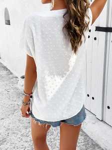 Rear view of white V-neck blouse featuring textured Swiss dots and lightweight fabric