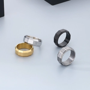Set of four geometric brushed stainless steel rings in gold, silver, black, and vintage finishes