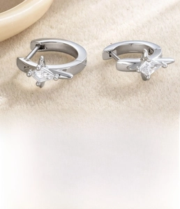 Detail of silver titanium steel hoop earrings featuring micro-set diamond-cut cubic zirconia