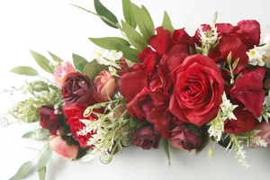 Detailed macro view of artificial red roses and white floral arrangement for wedding decor