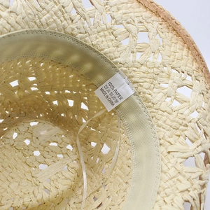 Detail shot of straw hat interior with 100% paper material label and sweatband
