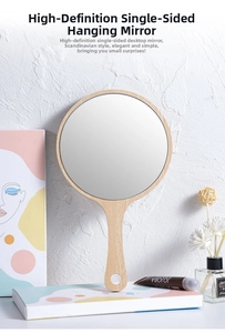 Detail of a round wooden handheld mirror featuring a handle with a hole for easy hanging