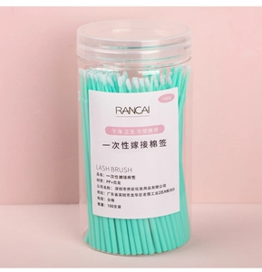 Close-up of disposable eyelash micro brushes in a clear jar with mint green handles