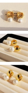 Detailed view of wide gold hoop earrings with white pearls on vintage display