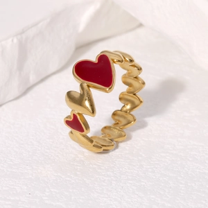 Polished heart-shaped stainless steel open ring with red oil-drop detail on white background