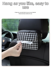 Car tissue box with black and white houndstooth pattern hanging on leather headrest seat