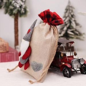 Christmas burlap gift bag with gnome pattern and red buffalo plaid drawstring closure