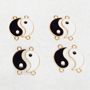Close-up of black and white Yin Yang alloy charms with double loops for DIY jewelry making