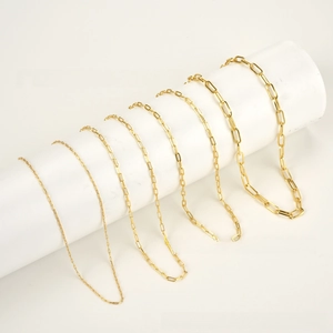 Five sizes of golden paperclip link chains displayed on white cylindrical props