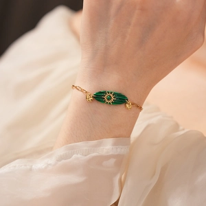Détail du bracelet chaîne dorée vintage avec pierre malachite verte et soleil