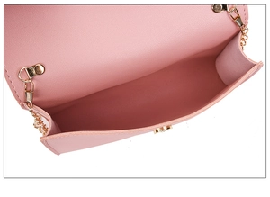 Detail view of the pink faux leather crossbody bag with magnetic closure and gold chain