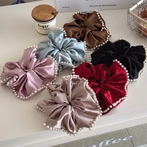 Elegant satin scrunchies set with pearl trim in six colors on a white tabletop