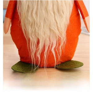 Macro shot of green felt feet and soft faux fur beard on autumn harvest gnome decor