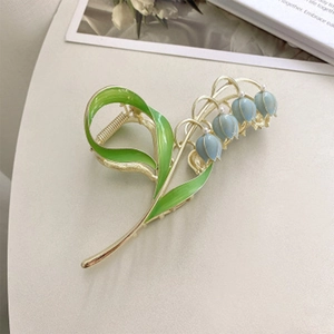 Eleganter Maiglöckchen-Haarclip mit blauen Blüten und Perlen auf goldener Metallbasis