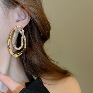 Close-up of gold irregular double hoop earrings with pavé rhinestones on model