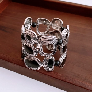 Close-up of vintage silver cuff bracelet with spiral texture and black bead details
