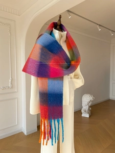 Close-up detail of oversized colorful plaid scarf with soft fringe and thick wool texture