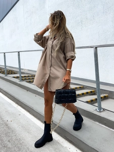 Detail of khaki oversized long-sleeve V-neck shirt dress with black woven handbag in street style