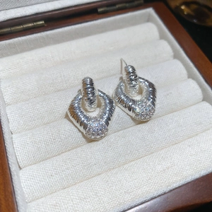 Dettaglio di orecchini a rombo in argento con diamanti in una scatola di velluto