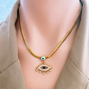 Collier en titane doré avec œil bleu et cristaux porté par un mannequin féminin