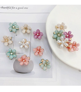 Vue détaillée de mini pinces à cheveux fleurs pastel avec détails de strass brillants