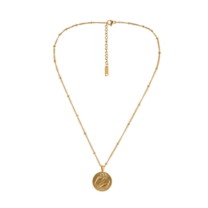 Macro detail of gold stainless steel necklace with Pisces zodiac coin and pearl chain
