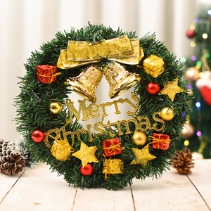 Close-up of a green PVC Christmas wreath with gold bells and Merry Christmas lettering