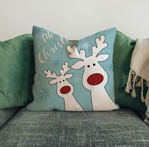 Detail eines Kissenbezugs mit Rentieren und Merry Christmas Text auf einem grauen Sofa