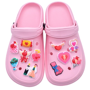 Pink clog shoes decorated with romantic wedding theme charms including love hearts and bows