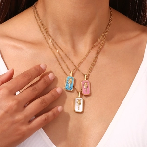 Detailed close-up of 18K gold-plated necklaces with colorful shell palm tree pendants