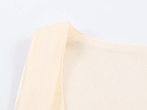 Dettaglio ravvicinato dell'abito midi beige chiaro che mostra le cuciture e la trama del tessuto