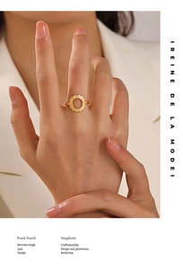 Close-up of a golden sunflower sunburst ring worn by a model on a minimalist background
