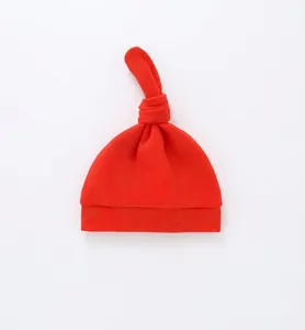 Detail of red newborn baby knotted hat in soft cotton jersey with rolled edge