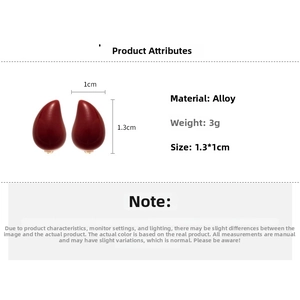 Macro detail of red teardrop earrings showing 1.3cm by 1cm size dimensions and stud design