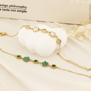 Detail of gold flower bracelets with mother-of-pearl and malachite clovers on silk