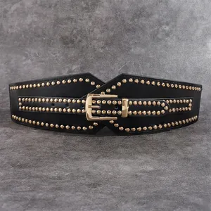 Detail of black leather corset belt with gold studs and large metallic pin buckle