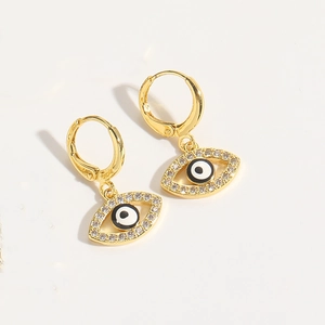 Close-up of gold hoop earrings with evil eye charms and sparkling crystals on white background