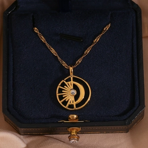 Macro view of 18K gold plated sun and moon pendant with a sparkling crystal in a gift box