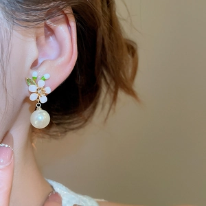Detail von 18 Karat vergoldeten Blumenohrringen mit Zirkonia und weißem Perlenanhänger