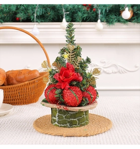 Detailed view of mini Christmas tree with red glitter balls and golden heart sequins