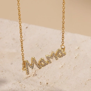 Makro-Detail des vergoldeten MAMA-Buchstabenanhängers mit Mikropave-Zirkonia-Kristallen