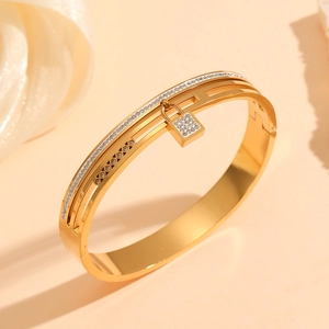Detail of gold double-layer hollow bracelet with pavé crystal lock pendant detail